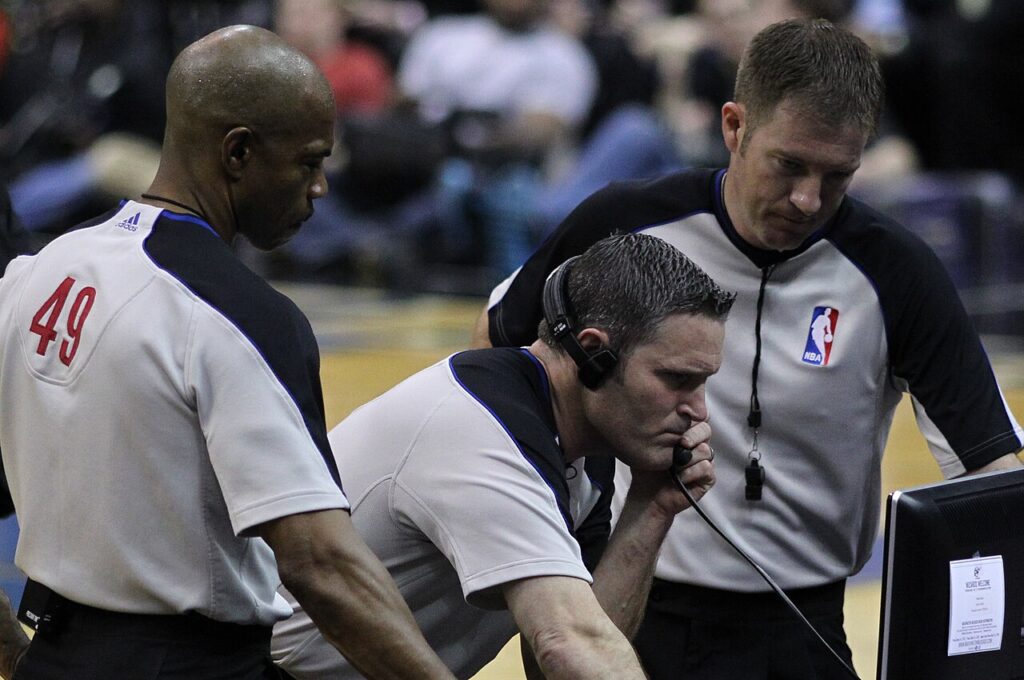NBA referees Tom Washington, Monty McCutchen and Brent Barnaky review a monitor during a 2011 game