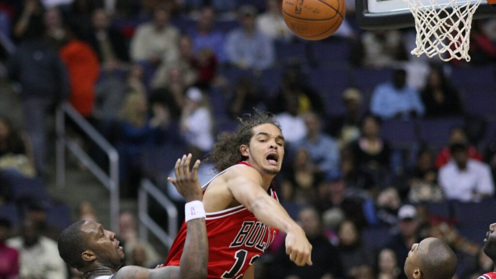 Joakim Noah in a red Bulls road jersey goes up for a rebound against the Washington Wizards