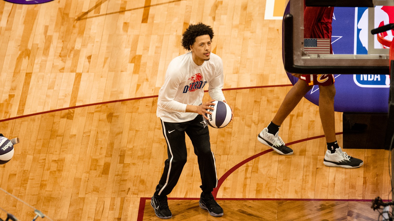 Cade Cunningham in a Detroit Pistons jersey holds the basketball