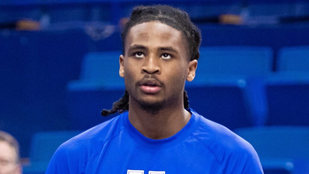 Cason Wallace in a blue Kentucky warmup shirt holds a basketball before a game