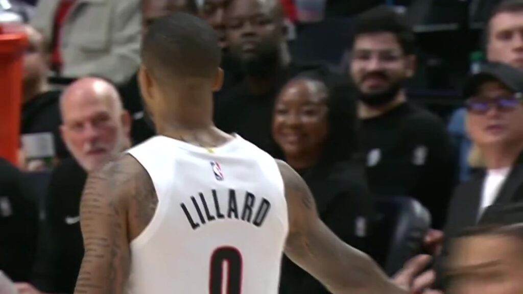 Damian Lillard of the Portland Trail Blazers walks past courtside fans during his return game against the Phoenix Suns
