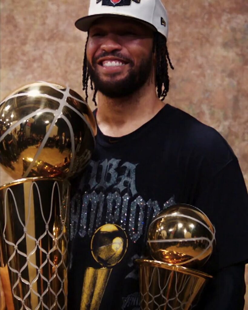 Jalen Brunson holding the championship trophy and the Finals MVP trophy