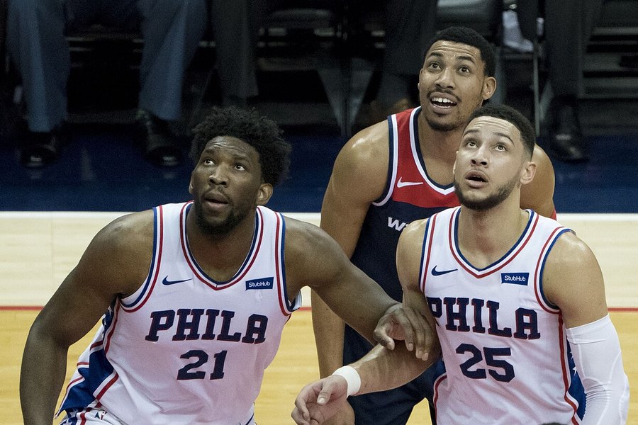 Joel Embiid and Ben Simmons of the Philadelphia 76ers waiting for a rebound during a game