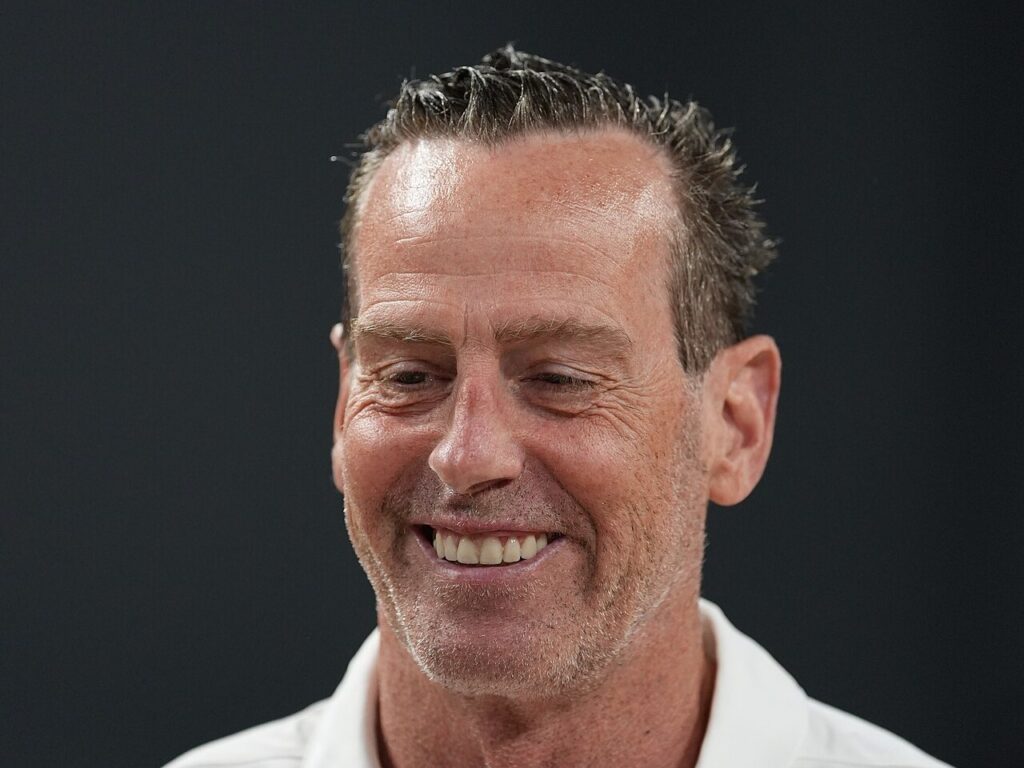 Cavaliers coach Kenny Atkinson smiles in a white polo shirt