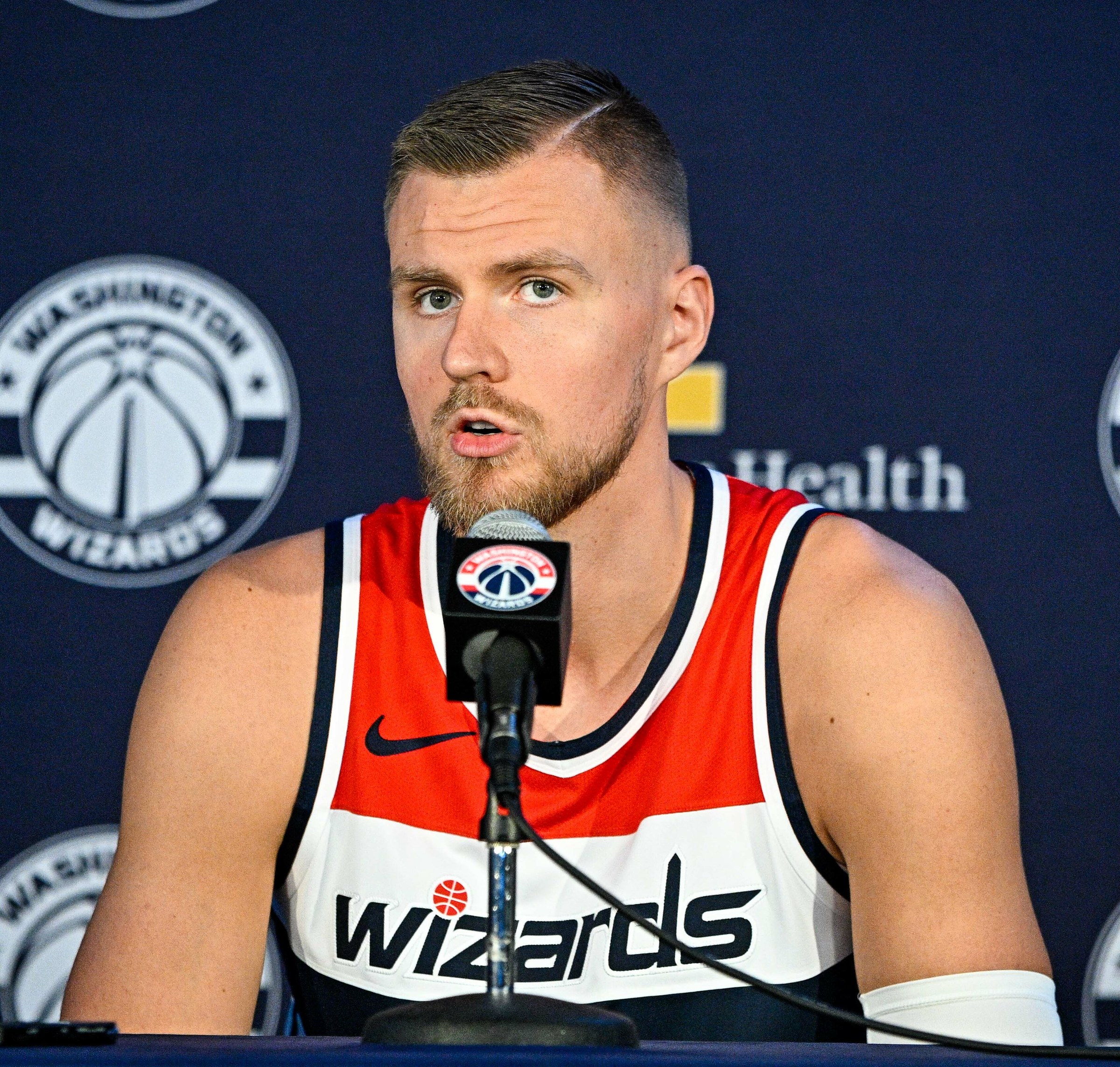 Kristaps Porzingis in a white Wizards uniform looking upcourt during an NBA game
