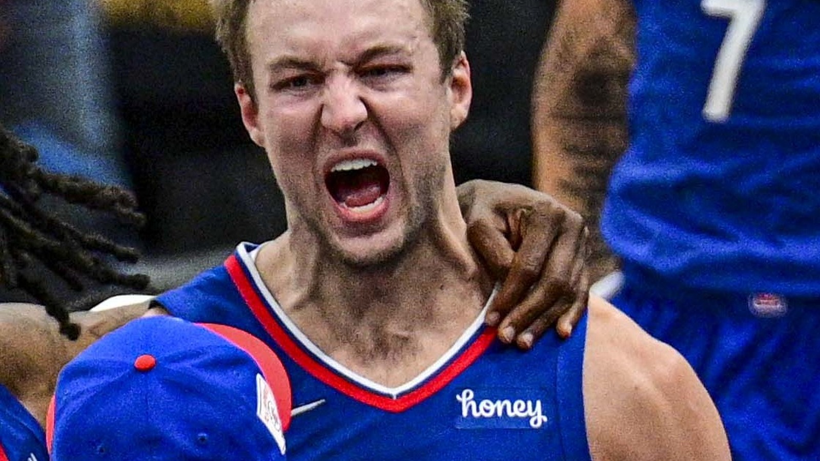 Luke Kennard celebrates in a Clippers jersey on the court