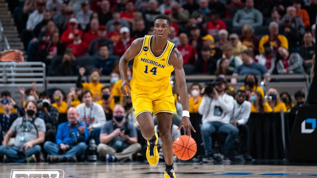 Moussa Diabaté dribbles in a Michigan jersey on a college court