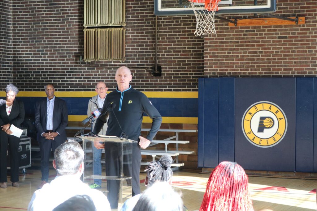 Pacers coach Rick Carlisle speaks at a podium in an Indianapolis gym