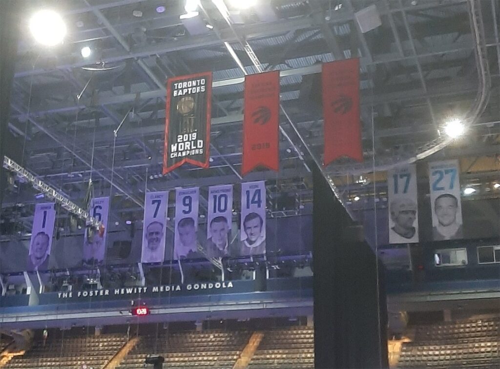 Toronto Raptors and Maple Leafs banners, including the Raptors 2019 championship banner, hanging in the rafters of Scotiabank Arena
