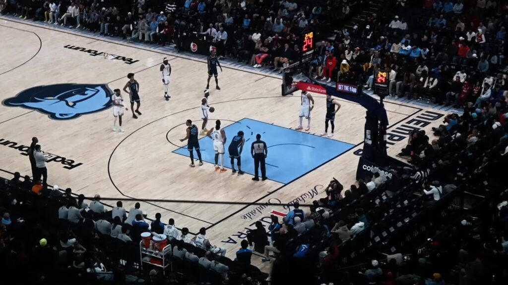 Shai Gilgeous-Alexander in a white Oklahoma City Thunder uniform shooting a free throw in Memphis, seen from the upper deck