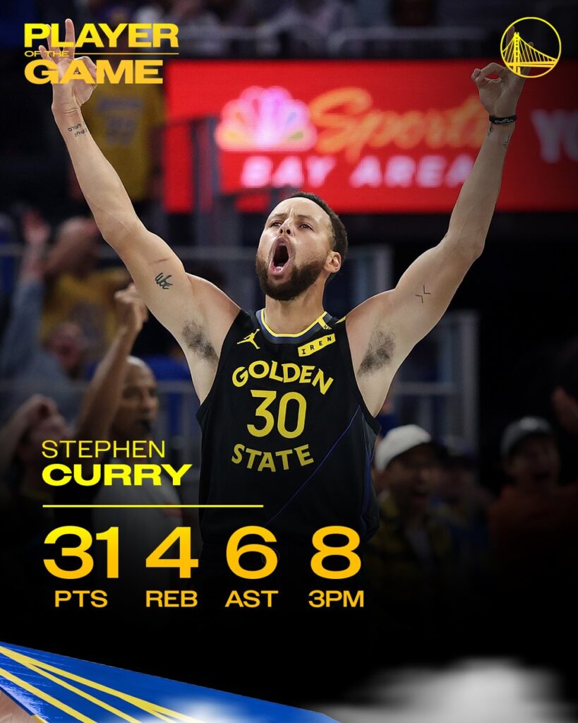 Stephen Curry raises both arms in celebration during the Warriors win over the Lakers