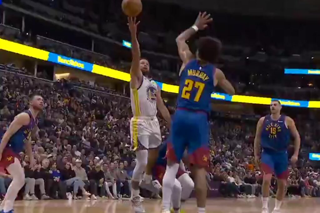 Stephen Curry of the Golden State Warriors shoots a floater over Jamal Murray in Denver